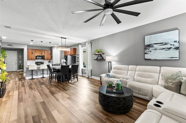 180 Azure Mist Way, Daytona Beach, FL 32124 - living area featuring ceiling fan, light wood-type flooring, and a textured ceiling