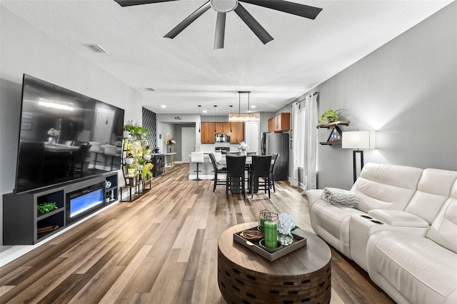 180 Azure Mist Way, Daytona Beach, FL 32124 - living area featuring ceiling fan, light wood finished floors, and a textured ceiling