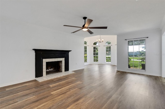 5722 Antler Trl, Lakeland, FL 33811 - unfurnished living room with a tile fireplace, wood finished floors, ceiling fan, a chandelier, and crown molding