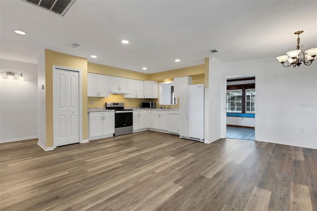 5722 Antler Trl, Lakeland, FL 33811 - kitchen with stainless steel appliances, light countertops, a chandelier, wood finished floors, and white cabinetry
