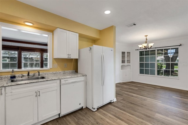 5722 Antler Trl, Lakeland, FL 33811 - kitchen featuring white appliances, a chandelier, white cabinetry, wood finished floors, and ornamental molding