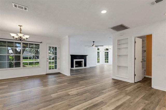 5722 Antler Trl, Lakeland, FL 33811 - unfurnished living room with a chandelier, built in features, a fireplace with raised hearth, ceiling fan, and wood finished floors
