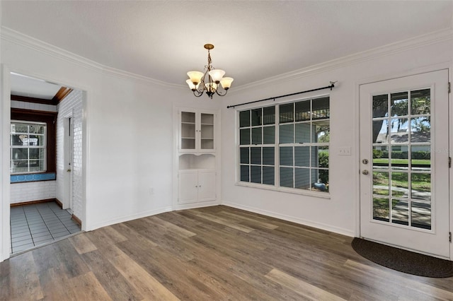 5722 Antler Trl, Lakeland, FL 33811 - unfurnished dining area featuring a chandelier, crown molding, built in shelves, and wood finished floors