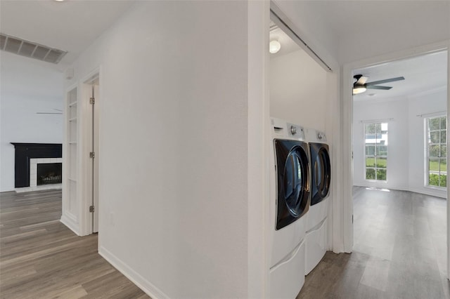 5722 Antler Trl, Lakeland, FL 33811 - washroom with washer and clothes dryer, wood finished floors, a ceiling fan, and a fireplace