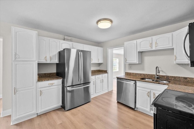 405 S 7th Ave, Bartow, FL 33830 - kitchen with appliances with stainless steel finishes, white cabinets, light wood-type flooring, and dark stone countertops