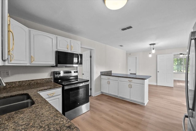405 S 7th Ave, Bartow, FL 33830 - kitchen featuring stainless steel appliances, white cabinetry, light wood-style floors, and a peninsula