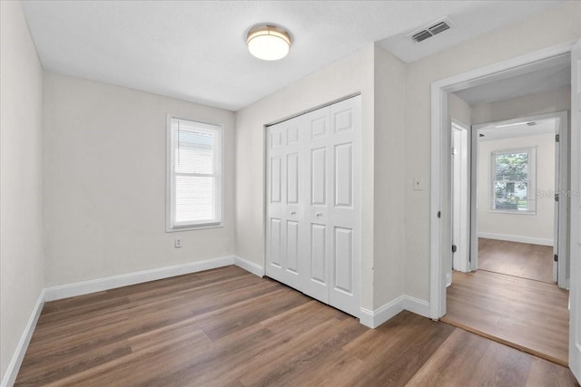 405 S 7th Ave, Bartow, FL 33830 - unfurnished bedroom with wood finished floors, multiple windows, and a closet