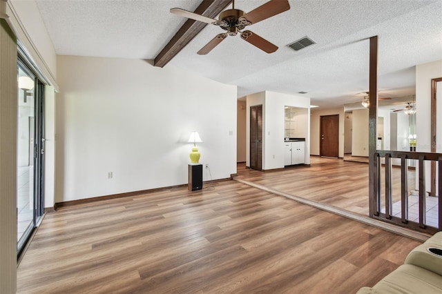 849 Rockingham Rd, Lakeland, FL 33809 - unfurnished living room with ceiling fan, a textured ceiling, light wood finished floors, and beam ceiling