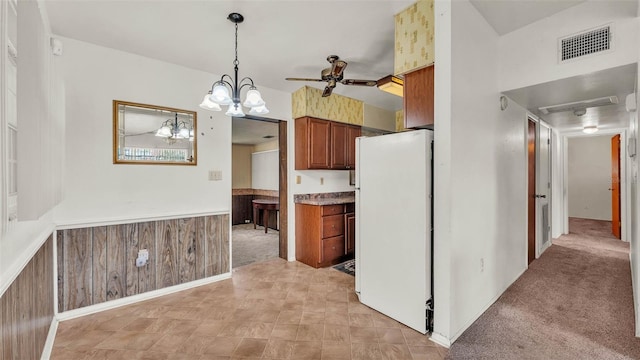 640 Forrest Dr, Bartow, FL 33830 - kitchen with freestanding refrigerator, brown cabinetry, a chandelier, wainscoting, and hanging light fixtures