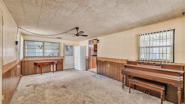 640 Forrest Dr, Bartow, FL 33830 - sitting room featuring healthy amount of natural light, carpet, wood walls, and ceiling fan