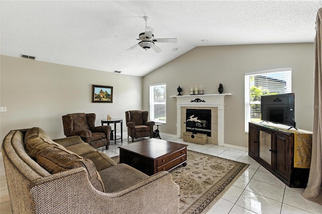 6410 Beechnut Dr, Lakeland, FL 33813 - living room with a ceiling fan, healthy amount of natural light, vaulted ceiling, a tiled fireplace, and a textured ceiling