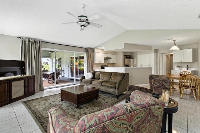 6410 Beechnut Dr, Lakeland, FL 33813 - living room with lofted ceiling, light tile patterned flooring, a ceiling fan, and a textured ceiling