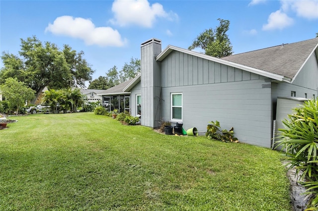 6410 Beechnut Dr, Lakeland, FL 33813 - view of side of property with a chimney, a lawn, and roof with shingles