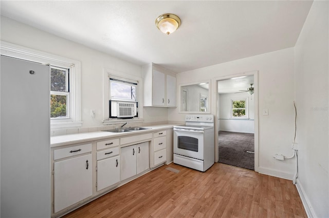 1133 Bryn Mawr Ave, Lake Wales, FL 33853 - kitchen with white appliances, white cabinetry, light wood-type flooring, cooling unit, and ceiling fan