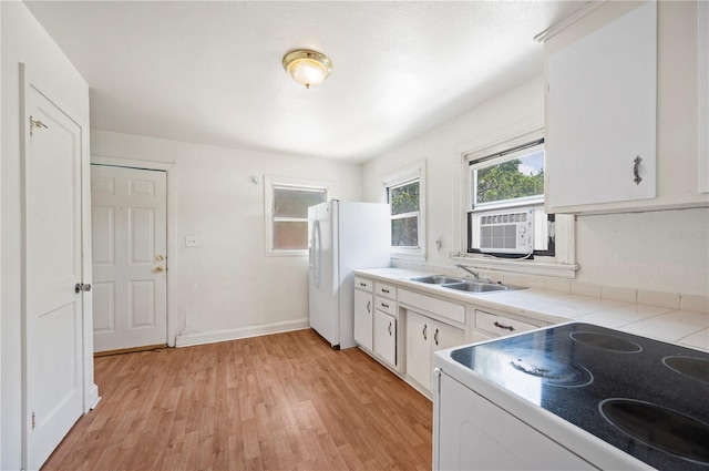 1133 Bryn Mawr Ave, Lake Wales, FL 33853 - kitchen with stove, freestanding refrigerator, white cabinets, light wood finished floors, and light countertops