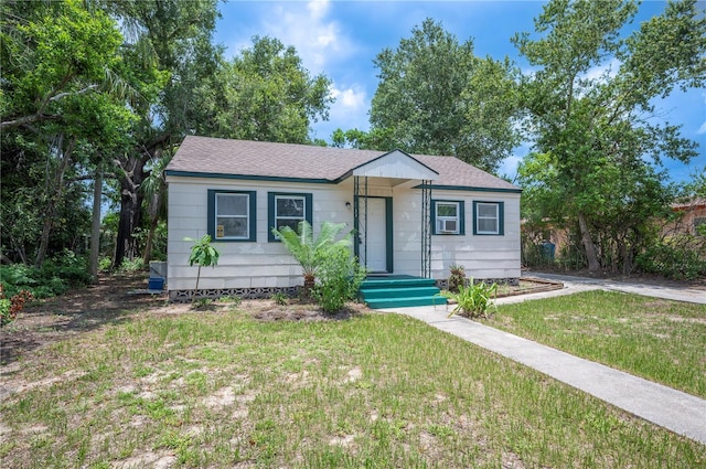 1133 Bryn Mawr Ave, Lake Wales, FL 33853 - view of front facade with a front lawn and roof with shingles