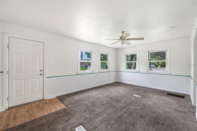 1133 Bryn Mawr Ave, Lake Wales, FL 33853 - carpeted empty room with a ceiling fan, wainscoting, a textured ceiling, and wood finished floors