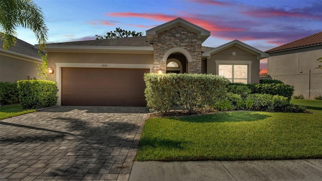 11825 Frost Aster Dr, Riverview, FL 33579 - view of front of house with stucco siding, decorative driveway, a garage, and a yard