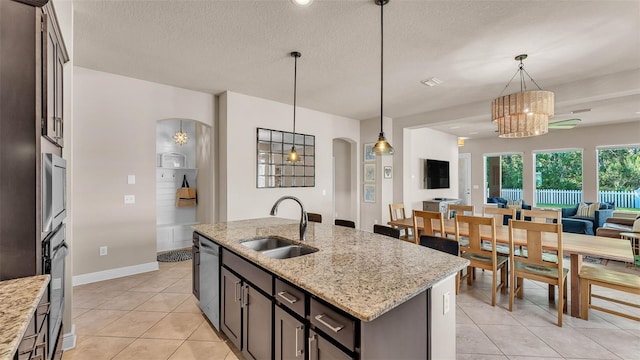 11825 Frost Aster Dr, Riverview, FL 33579 - kitchen featuring arched walkways, open floor plan, appliances with stainless steel finishes, a chandelier, and light tile patterned flooring