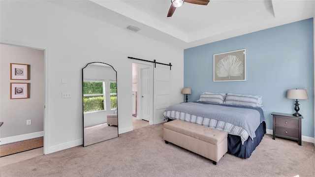 11825 Frost Aster Dr, Riverview, FL 33579 - carpeted bedroom featuring a barn door, a tray ceiling, and a ceiling fan