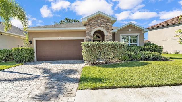11825 Frost Aster Dr, Riverview, FL 33579 - view of front of house featuring stucco siding, decorative driveway, stone siding, a front lawn, and a garage
