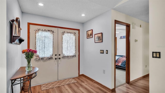 6406 Butternut Dr, Lakeland, FL 33813 - foyer with light wood-style flooring, french doors, a textured ceiling, and recessed lighting