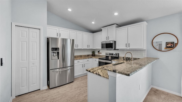 3739 Peregrine Way, Lakeland, FL 33811 - kitchen featuring appliances with stainless steel finishes, stone countertops, white cabinetry, decorative backsplash, and vaulted ceiling