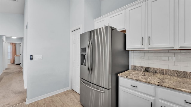 3739 Peregrine Way, Lakeland, FL 33811 - kitchen featuring stainless steel fridge, decorative backsplash, white cabinetry, and light stone countertops