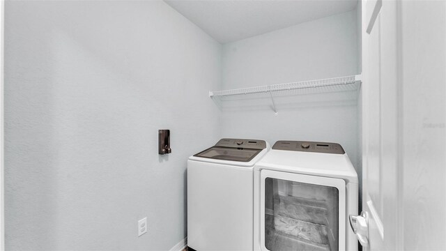 3739 Peregrine Way, Lakeland, FL 33811 - washroom featuring washing machine and clothes dryer and baseboards