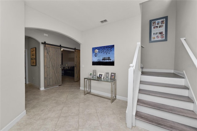 1044 Oliveto Verdi Ct, Brandon, FL 33511 - stairway with a barn door, arched walkways, and tile patterned flooring
