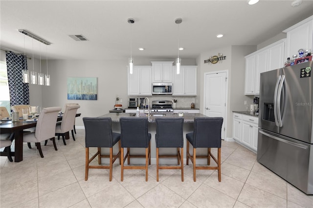 1044 Oliveto Verdi Ct, Brandon, FL 33511 - kitchen with stainless steel appliances, a breakfast bar, white cabinets, and recessed lighting