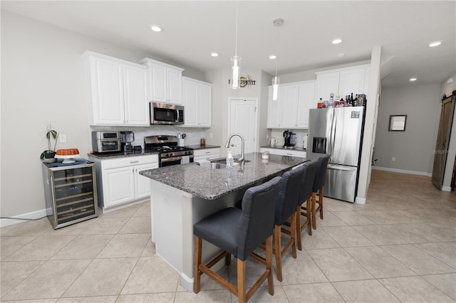 1044 Oliveto Verdi Ct, Brandon, FL 33511 - kitchen featuring stainless steel appliances, beverage cooler, light tile patterned flooring, a kitchen bar, and white cabinetry