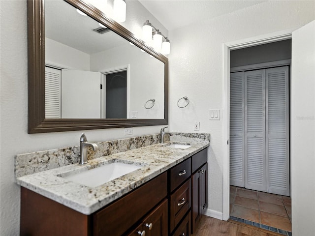 1232 Fairlee St, Lakeland, FL 33813 - bathroom featuring a closet, double vanity, and wood finished floors