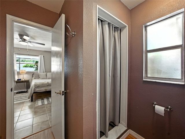 1232 Fairlee St, Lakeland, FL 33813 - full bath with ceiling fan, ensuite bathroom, a textured wall, curtained shower, and tile patterned flooring