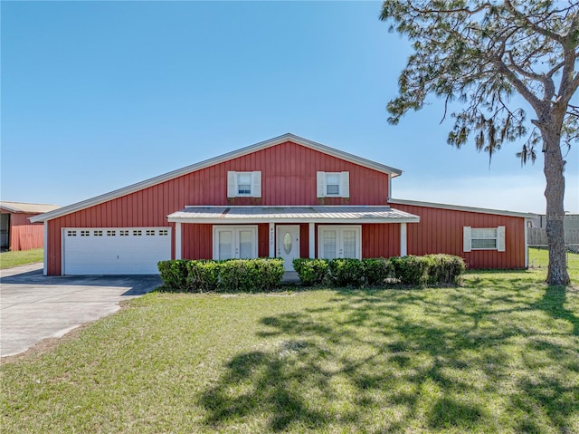 4230 Viola Rd, Lakeland, FL 33810 - traditional home with french doors, a front lawn, concrete driveway, a metal roof, and board and batten siding
