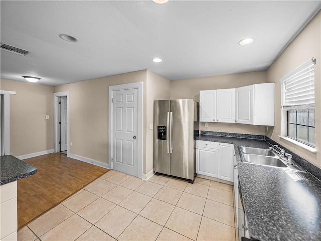 4230 Viola Rd, Lakeland, FL 33810 - kitchen featuring stainless steel refrigerator with ice dispenser, white cabinetry, dark countertops, light tile patterned floors, and recessed lighting