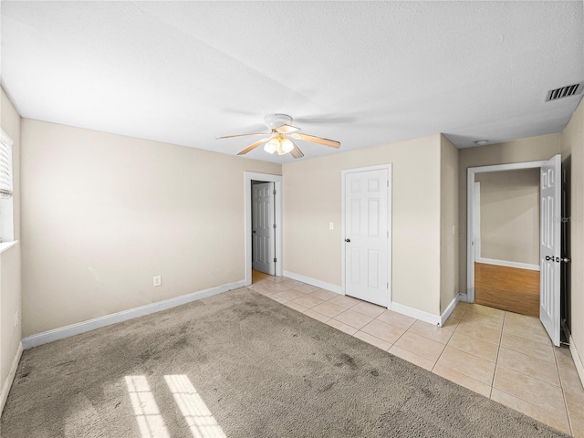 4230 Viola Rd, Lakeland, FL 33810 - unfurnished bedroom with tile patterned flooring, a ceiling fan, a textured ceiling, and carpet floors