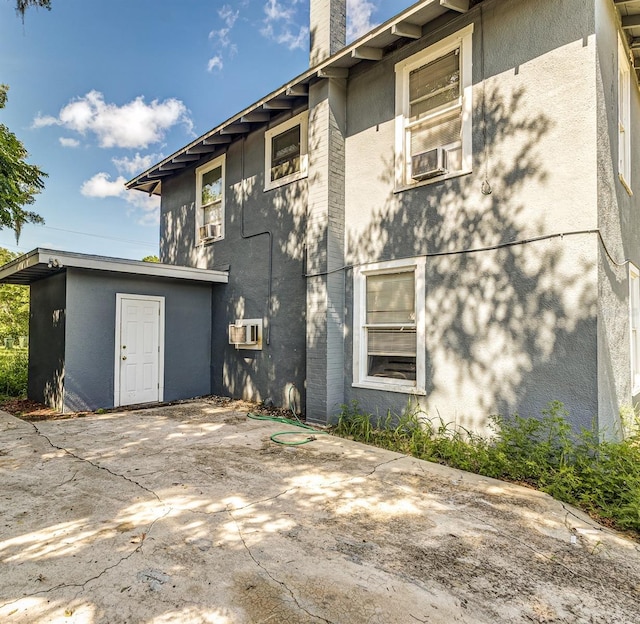 121 F Ave SW, Winter Haven, FL 33880 - back of house with a patio, stucco siding, a chimney, and cooling unit