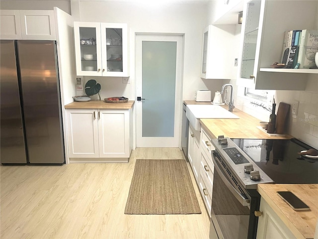 4718 Crystal Ave, Sarasota, FL 34231 - kitchen with appliances with stainless steel finishes, butcher block counters, light wood-type flooring, and white cabinetry