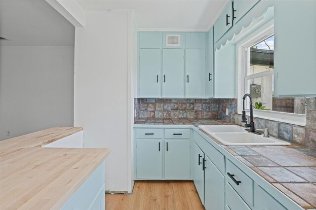 275 Garden Rd, Venice, FL 34293 - kitchen featuring decorative backsplash, light wood-style floors, and tile counters