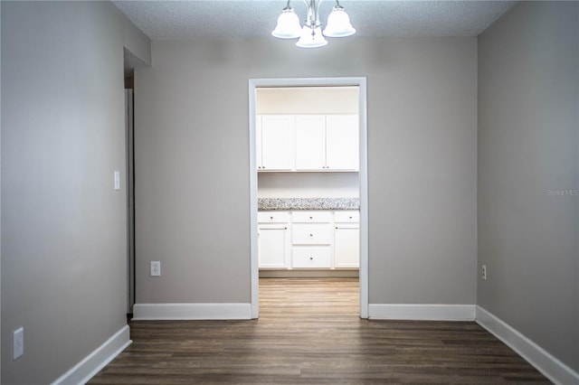 3542 Raintree Ct, Lakeland, FL 33803 - unfurnished room featuring a chandelier, dark wood-type flooring, and a textured ceiling