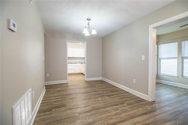 3542 Raintree Ct, Lakeland, FL 33803 - spare room featuring a chandelier, dark wood-style flooring, and a textured ceiling