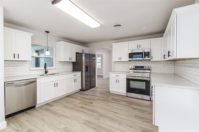 508 Boger Blvd N, Lakeland, FL 33803 - kitchen featuring stainless steel appliances, light countertops, light wood-style flooring, and decorative backsplash