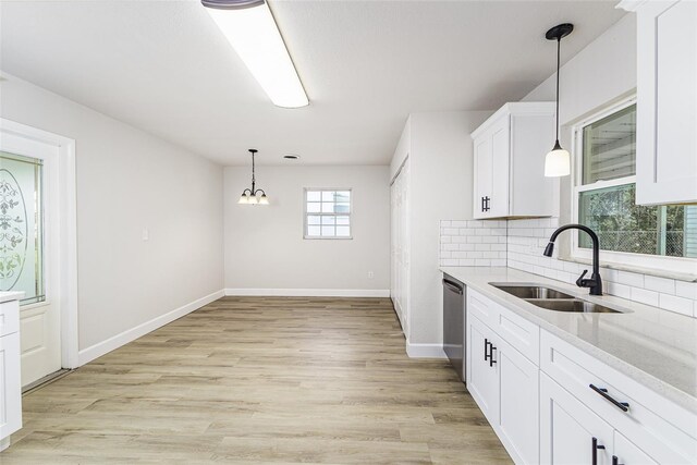 508 Boger Blvd N, Lakeland, FL 33803 - kitchen featuring dishwasher, backsplash, light countertops, white cabinets, and a chandelier