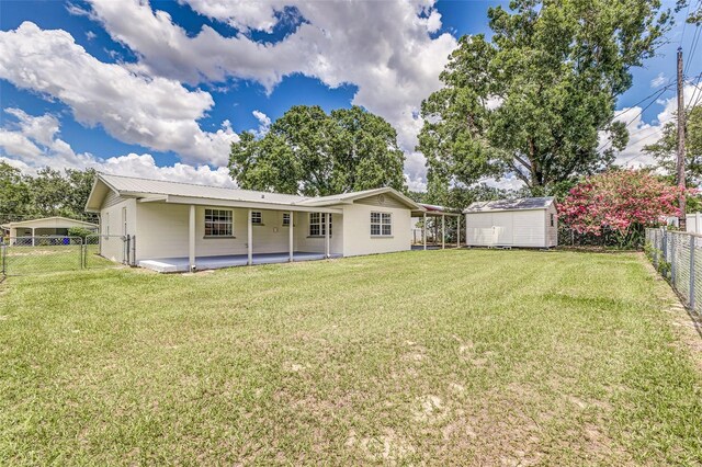 508 Boger Blvd N, Lakeland, FL 33803 - rear view of house with a fenced backyard, a shed, a patio, a gate, and a metal roof