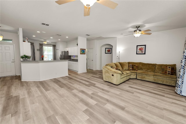 4242 Whistlewood Cir, Lakeland, FL 33811 - living room featuring a ceiling fan, light wood finished floors, recessed lighting, and arched walkways