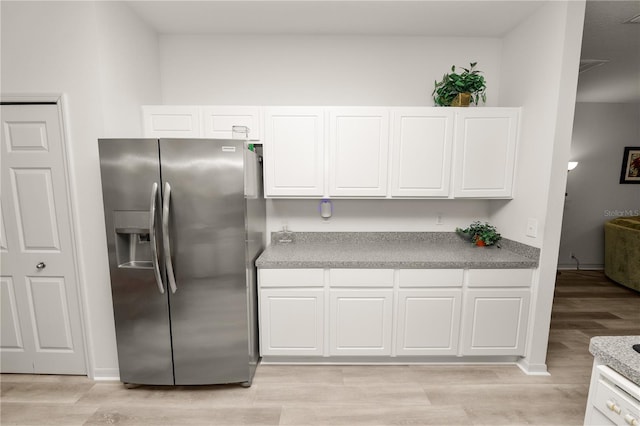 4242 Whistlewood Cir, Lakeland, FL 33811 - kitchen with stainless steel refrigerator with ice dispenser, light wood-style floors, and white cabinetry