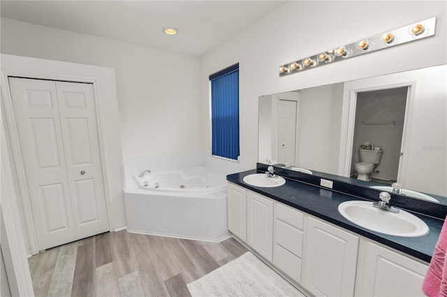 4242 Whistlewood Cir, Lakeland, FL 33811 - bathroom with a tub with jets, double vanity, wood finished floors, and a closet