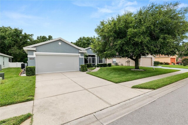 4242 Whistlewood Cir, Lakeland, FL 33811 - single story home featuring a front yard, concrete driveway, an attached garage, and stucco siding
