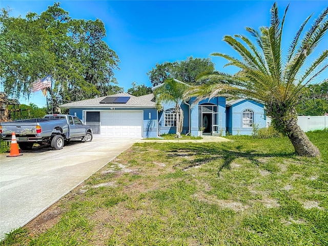 173 Portland Ave, Spring Hill, FL 34606 - single story home featuring solar panels, a garage, driveway, and stucco siding